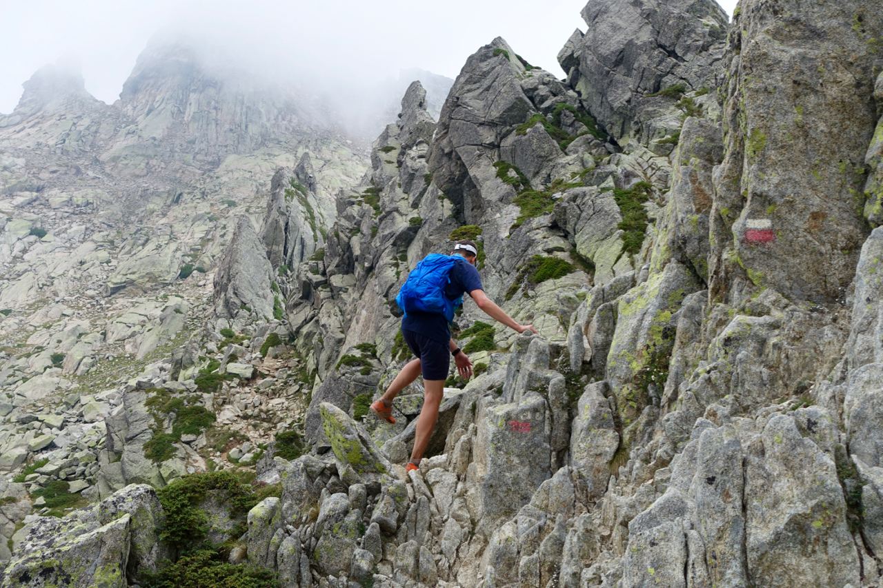 Scrambling längs bergsryggen med dimma